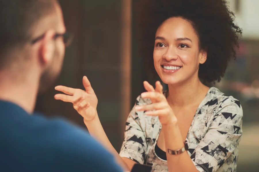 Duas pessoas a conversar de perto, uma delas a gesticular enquanto fala