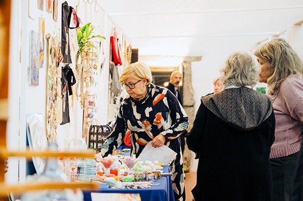 Visitantes a ver peças de artesanato expostas no Celeiro dos Cónegos, na edição de 2025 do Moreira com Arte