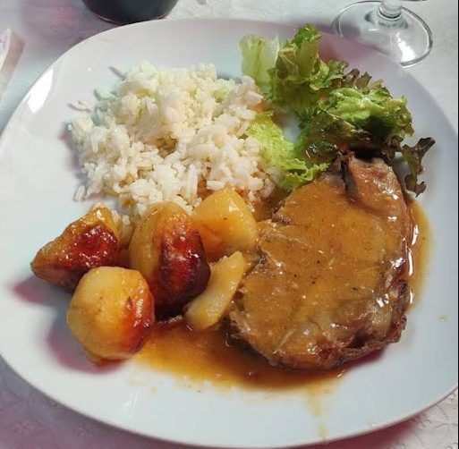 Costeleta de porco com molho, arroz branco e batata assada, no Bar do Clube Académico