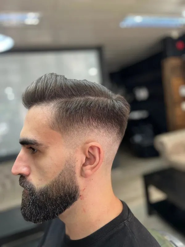 Barba aparada e corte com desvanecido, em perfil, na Barbearia Garcia & Tatuagem