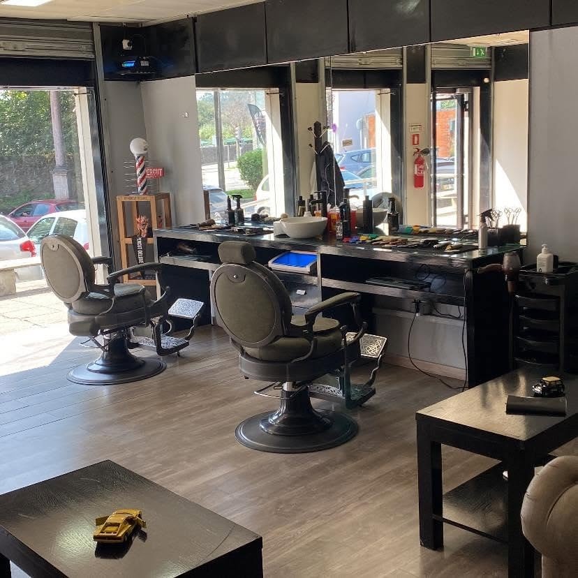 Interior da Barbearia Garcia & Tatuagem, com cadeiras de barbeiro vintage e balcão de produtos