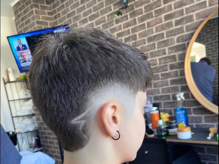 Corte com desvanecido e desenho rapado atrás da orelha, feito na Barbearia Big John