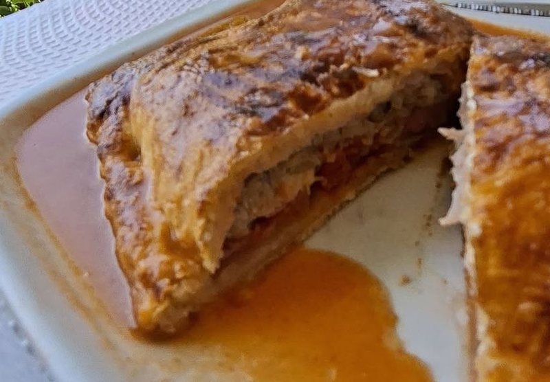Corte da francesinha de massa folhada do Cantinho da Manela, a mostrar o recheio por dentro