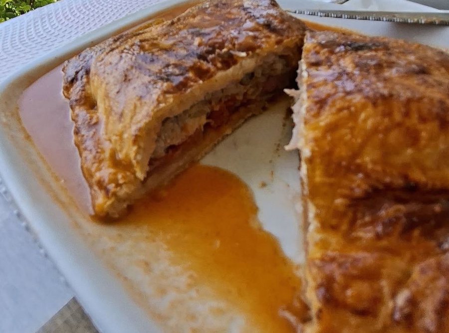 Francesinha de massa folhada, cortada ao meio, com ovo e molho, no Cantinho da Manela