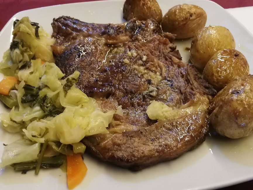 Costeleta grelhada com batatas a murro e couve salteada, servida na Cervejaria Stone, em Maia
