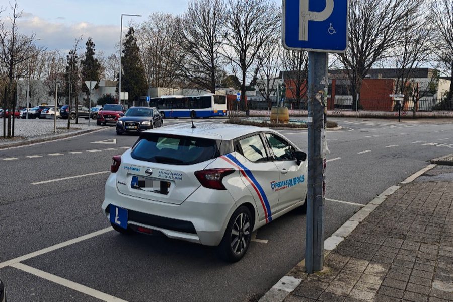 Carro de aprendizagem da Escola de Condução Pedras Rubras, com a placa L, estacionado junto à Praça do Exército Libertador