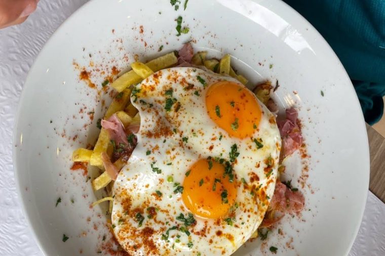 Prato combinado com ovos estrelados, batata frita e presunto, servido no Grelha & Brasa