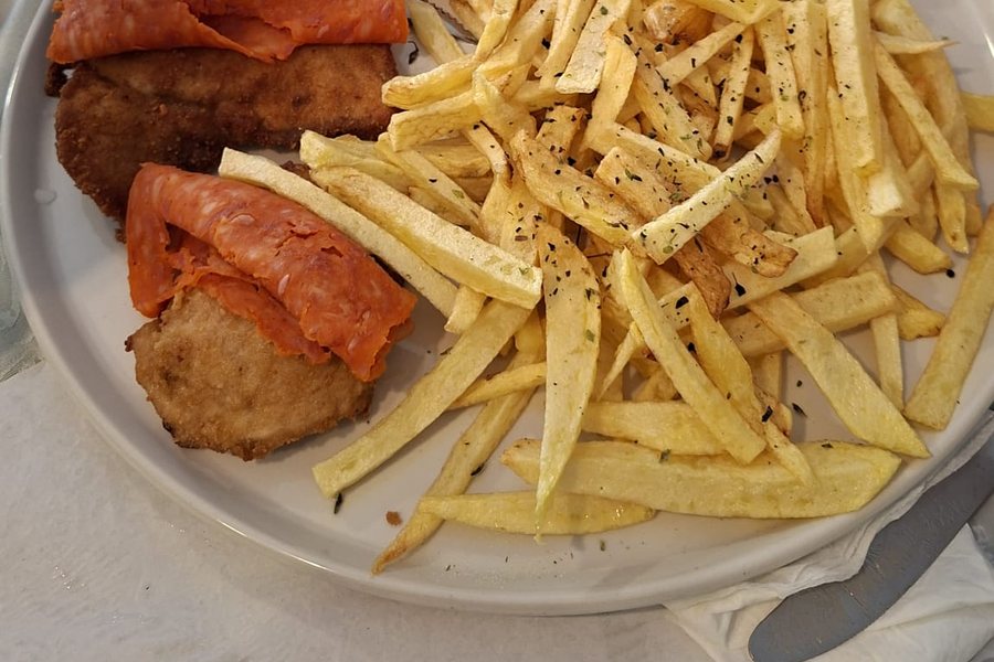 Prato misto com escalopes panados e chouriço assado, acompanhados de batata frita, no Kubata Grill Bistro