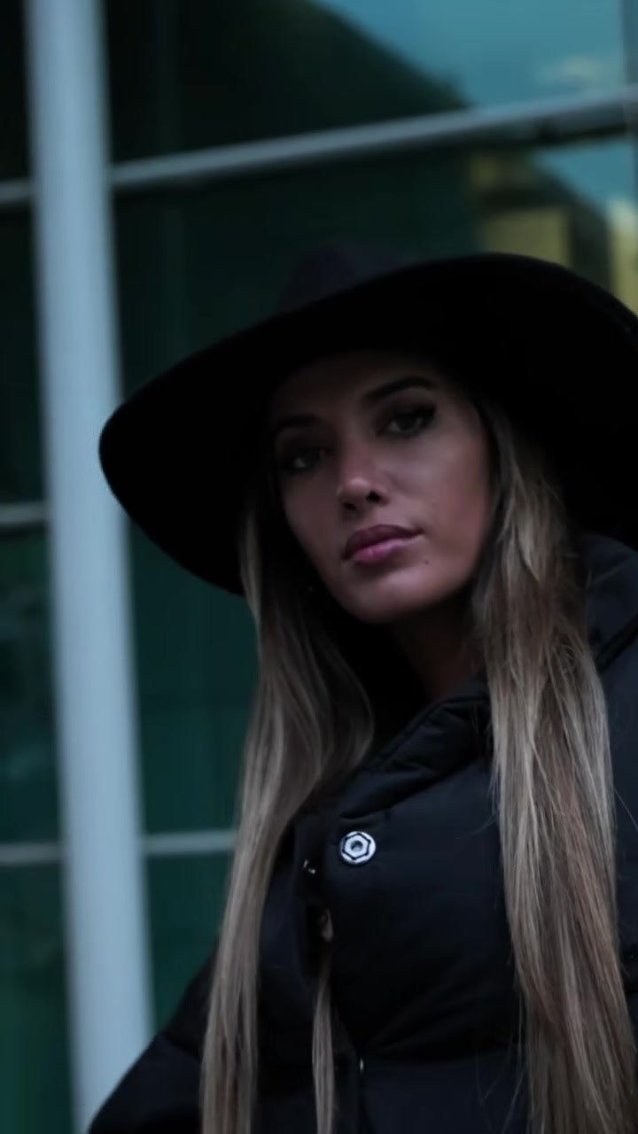 Retrato de um look da Lady Space, com chapéu preto de abas largas e casaco preto