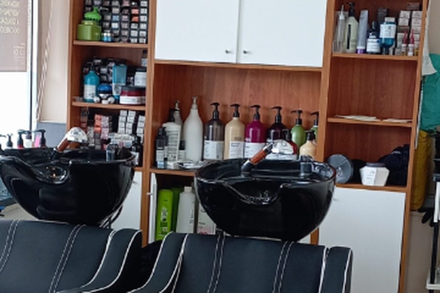 Lavatórios e prateleira de produtos no interior do Lúcia Fernandes Cabeleireiros, em Pedras Rubras