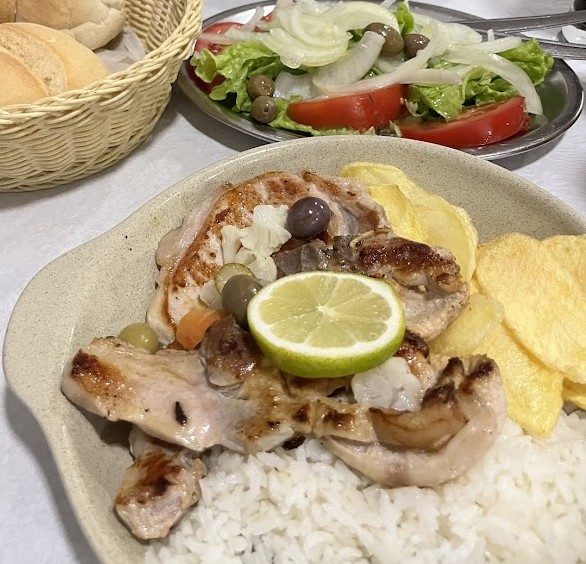 Carne grelhada com rodela de lima, azeitonas, batata frita e arroz branco, com salada de alface, tomate e cebola ao lado, no restaurante O Banquinho