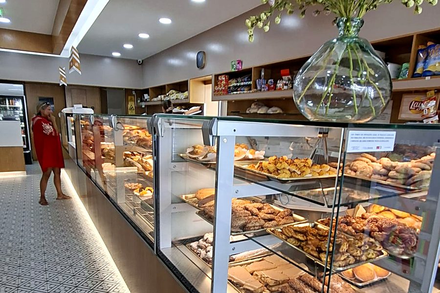 Interior da Pastelaria São Marcos, com as vitrinas de bolos e o balcão ao fundo
