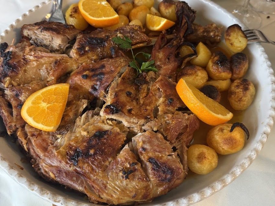 Travessa de cabrito assado no forno do Restaurante Malheiro, com batatas assadas e gomos de laranja