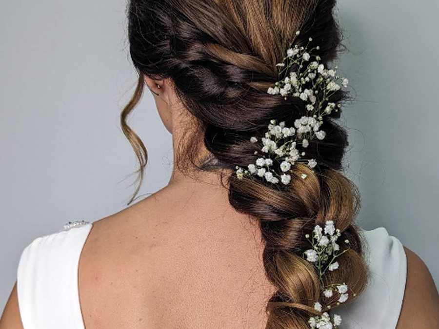 Trança com flores brancas entrelaçadas, penteado de noiva feito no Studios Liliana Sousa