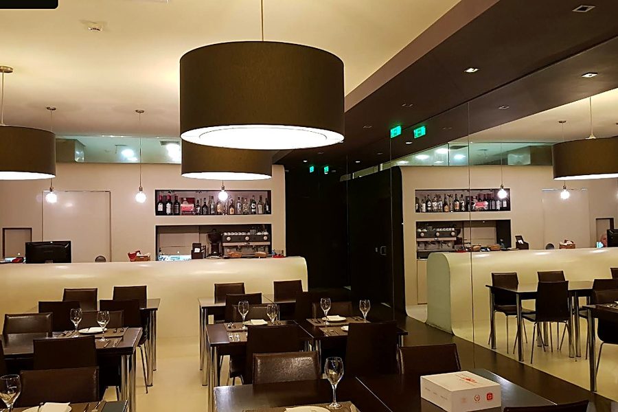 Sala do restaurante Tomar de Sal, com mesas postas, candeeiros redondos e balcão ao fundo