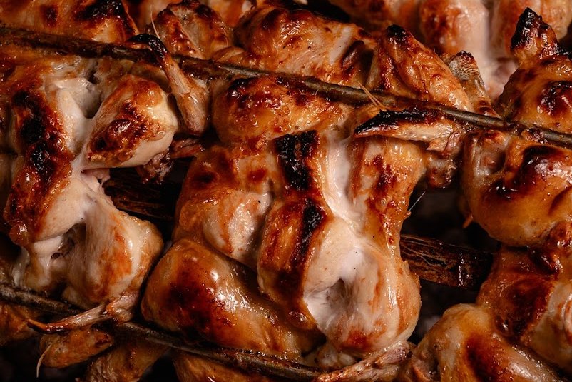 Frango a assar em espetos sobre brasas de carvão, no Tourigalo, na Maia
