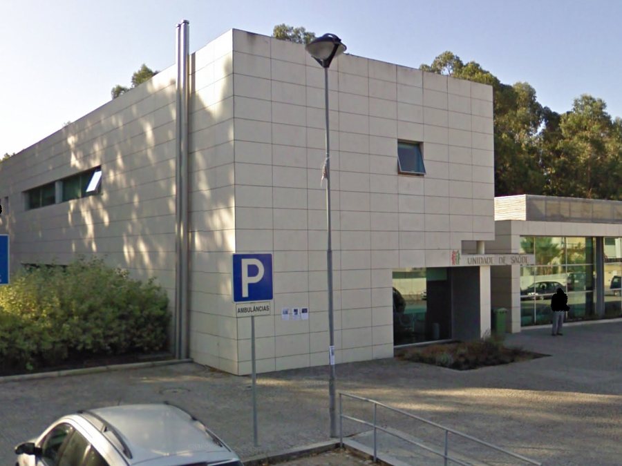 Edifício novo da Unidade de Saúde Familiar de Pedras Rubras, fachada branca com vidros e parque de estacionamento