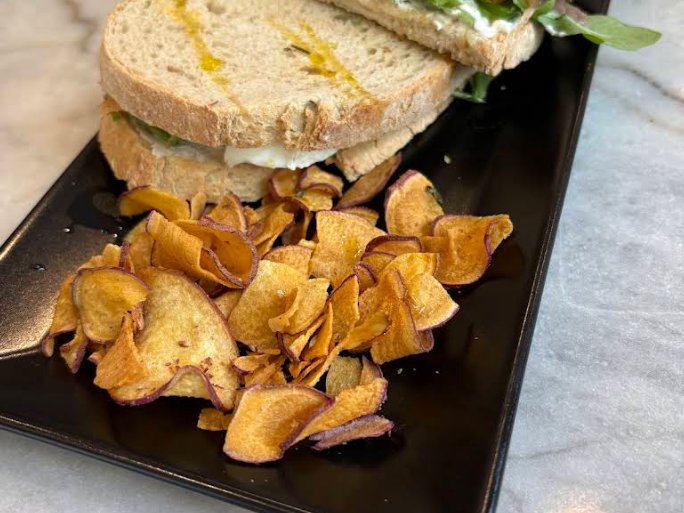 Sandes de salmão fumado com ovo e rúcula, com chips de batata-doce, servida no Velvet