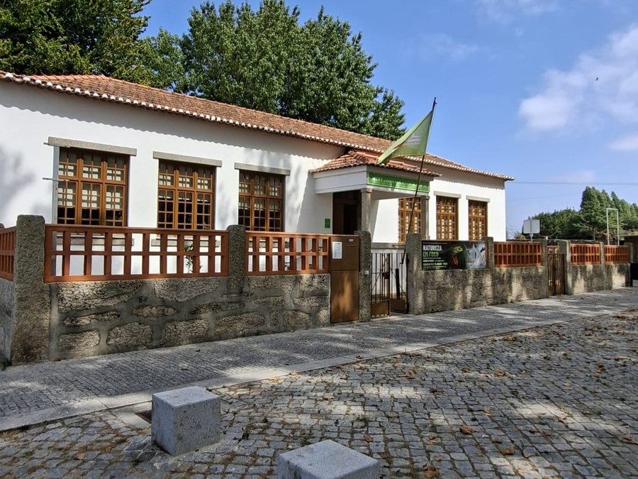 Fachada da antiga Escola Primária de Pedras Rubras, hoje sede da AEPPR, com a bandeira verde da associação