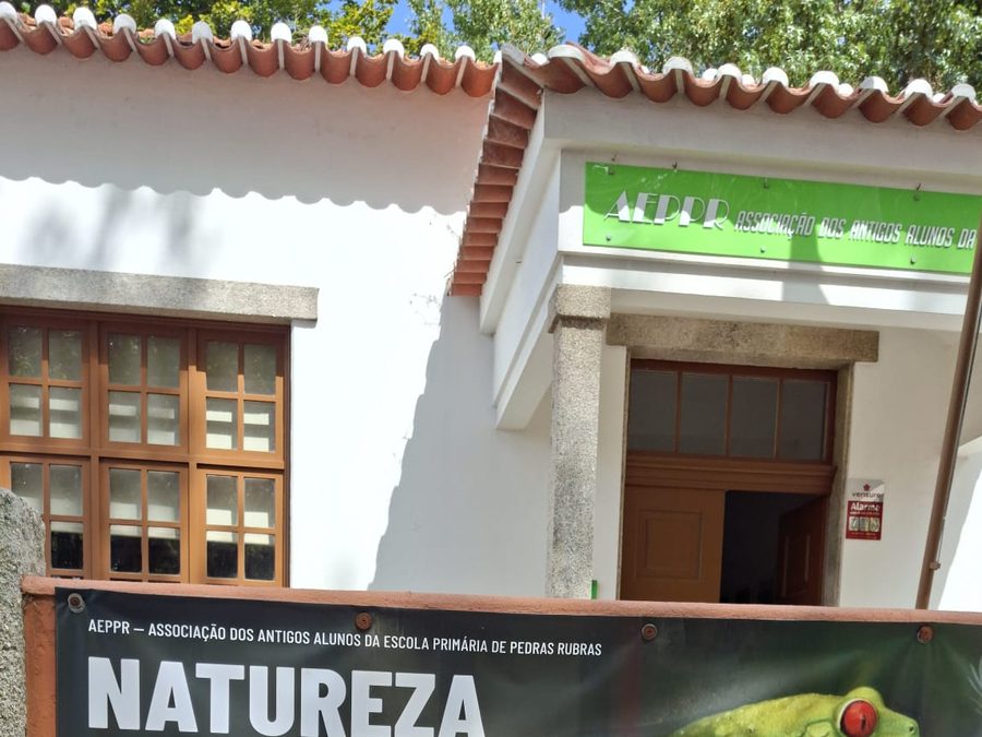 Cartaz do ciclo de palestras Natureza em Foco, organizado pela AEPPR, afixado no muro à entrada da antiga escola