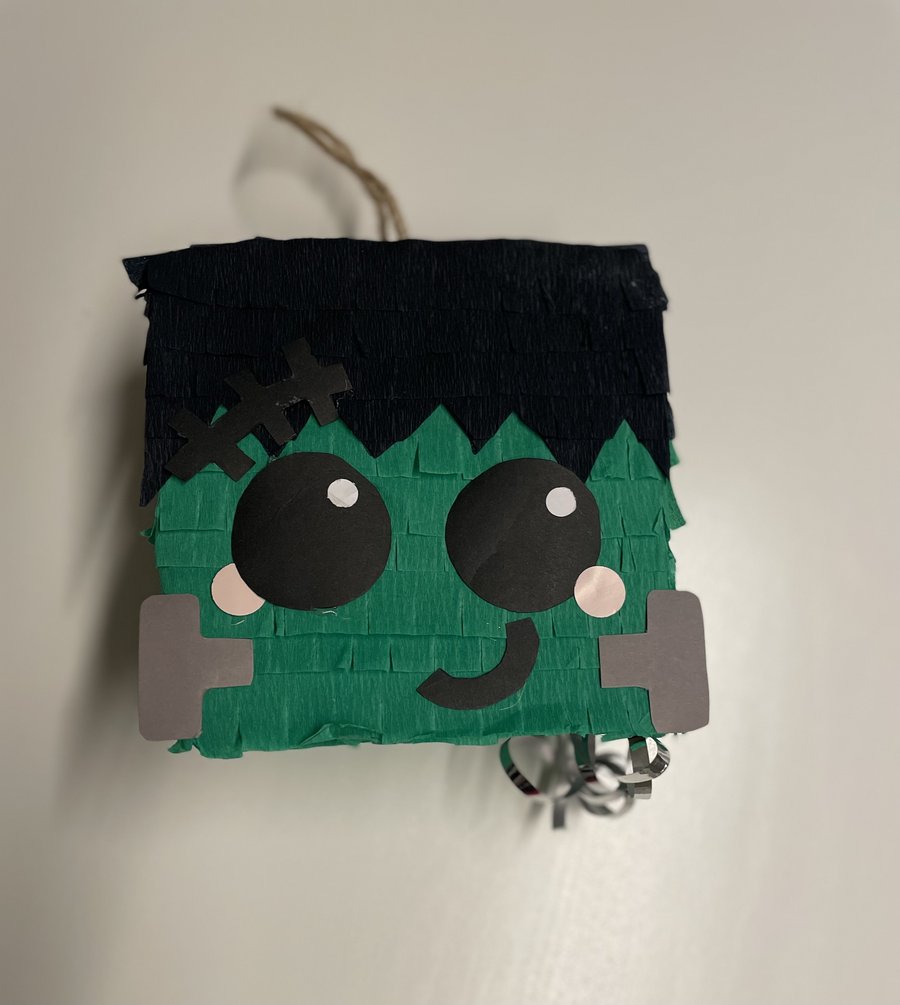 Pinhata do Frankenstein em fundo claro, com cicatriz e parafusos de papel