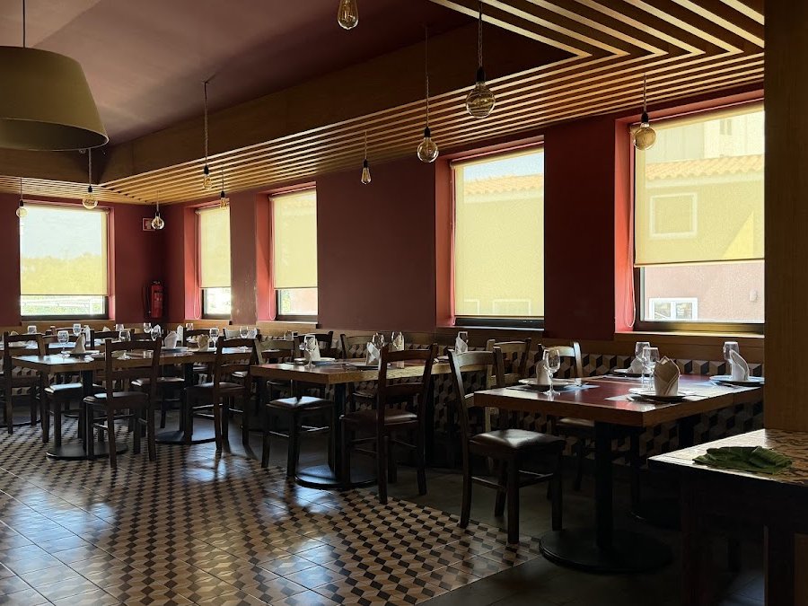 Sala do Tourigalo com mesas postas, chão em xadrez e janelas grandes